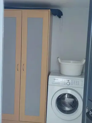 a laundry room with a washing machine and a cabinet at Casa d' Avó Zeza in Jardim do Mar