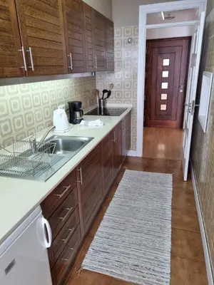 a kitchen with wooden cabinets and a sink at Ocean at your feet! in Funchal