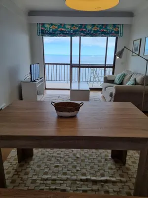 a wooden table in a living room with a view of the ocean at Ocean at your feet! in Funchal