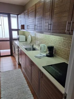 a kitchen with wooden cabinets and a sink and a counter at Ocean at your feet! in Funchal
