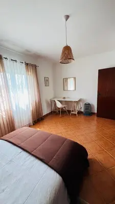a bedroom with a bed and a table in a room at Quinta dos Moledros in Figueira