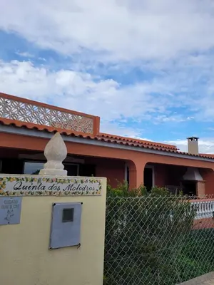 a building with a fence in front of a house at Quinta dos Moledros in Figueira