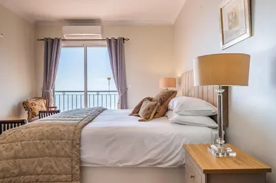 a bedroom with a large bed and a window at Casa grata in Arco da Calheta