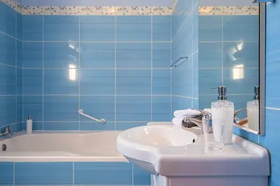 a blue tiled bathroom with a sink and a tub at Casa grata in Arco da Calheta