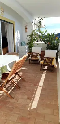 a patio with chairs and tables on a balcony at Superbe appartement vue sur mer à 180° Luz in Luz