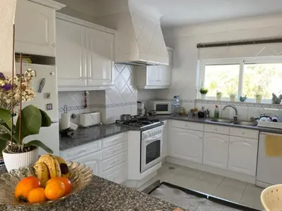 a kitchen with white cabinets and a bowl of fruit at Superbe appartement vue sur mer à 180° Luz in Luz