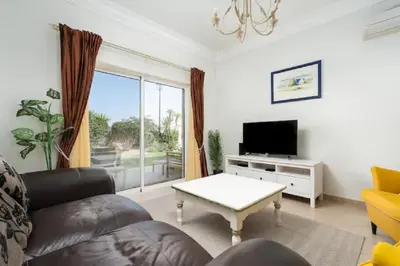 a living room with a couch and a tv at WOW Flat, Birdie, Golf, Spa & Swimming Pool (WIFI) in Lagos