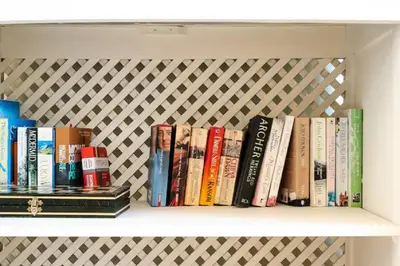 a row of books sitting on a shelf at WOW Flat, Birdie, Golf, Spa & Swimming Pool (WIFI) in Lagos