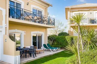 a house with a patio with chairs and a table at WOW Flat, Birdie, Golf, Spa & Swimming Pool (WIFI) in Lagos