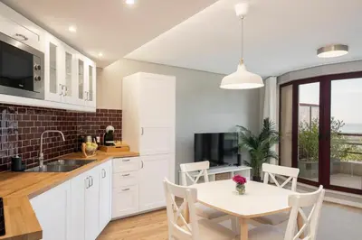 a kitchen with white cabinets and a table and chairs at The Boats Apartment by An Island Apart in Funchal
