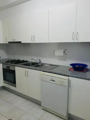 a kitchen with white cabinets and a stove top oven at Vista Dourada in Porto Santo