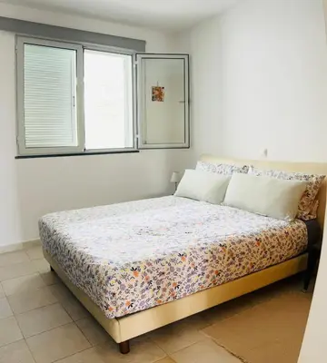 a bedroom with a bed in a room with two windows at Vista Dourada in Porto Santo