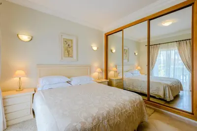 a bedroom with a large white bed and a mirror at Casa Sunny Days - Boavista Resort in Lagos