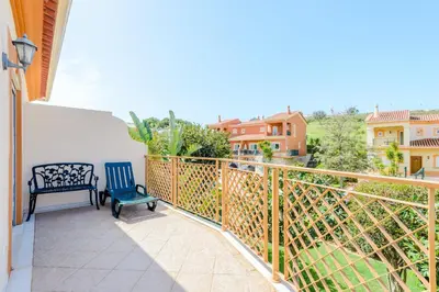 a balcony with a blue chair and a bench at Casa Sunny Days - Boavista Resort in Lagos