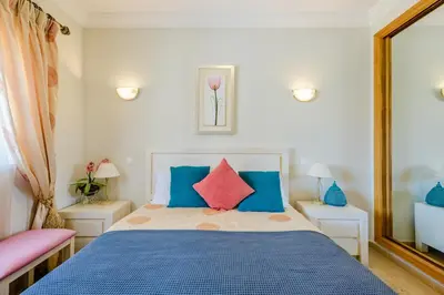 a bedroom with a bed with blue and red pillows at Casa Sunny Days - Boavista Resort in Lagos