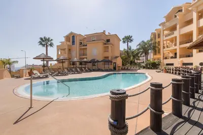 a swimming pool in a resort with chairs and umbrellas at Estrela da Praia da Luz - 2 Bedroom Sea View Apartment in Luz