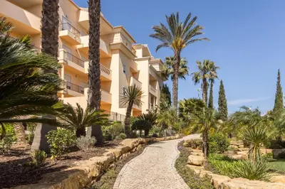 a path in front of a building with palm trees at Estrela da Praia da Luz - 2 Bedroom Sea View Apartment in Luz