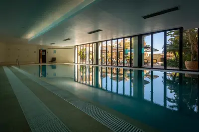 an indoor swimming pool in a building with windows at Estrela da Praia da Luz - 2 Bedroom Sea View Apartment in Luz