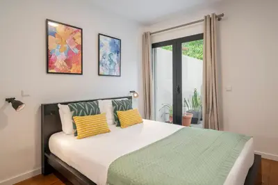a bedroom with a large bed with two yellow pillows at Barreiros II by An Island Apart in Funchal
