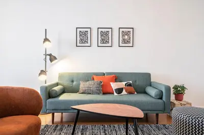 a living room with a blue couch with orange pillows at Barreiros II by An Island Apart in Funchal