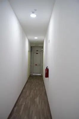 an empty hallway with a white wall and a door at Madeirarooms in Funchal
