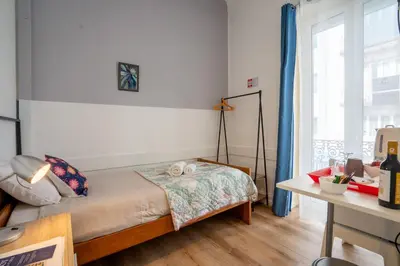 a bedroom with a bed with two towels and a window at Madeirarooms in Funchal