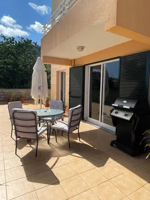 a patio with a table and chairs and a piano at Cantinho da Té in Câmara de Lobos