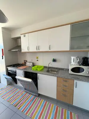 a kitchen with white cabinets and a sink at Cantinho da Té in Câmara de Lobos