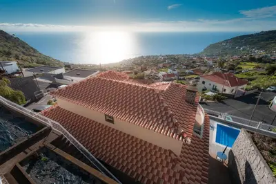 a view of a house with a view of the ocean at Sunnyside Villa in Arco da Calheta