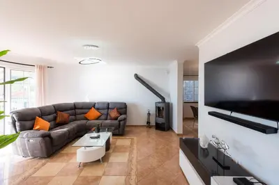 a living room with a couch and a tv at Sunnyside Villa in Arco da Calheta