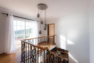 a staircase in a home with a large window at Sunnyside Villa in Arco da Calheta