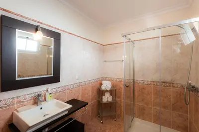 a bathroom with a sink and a shower at Sunnyside Villa in Arco da Calheta