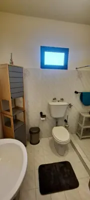 a bathroom with a white toilet and a sink at Chalé Seixal - Sea View in Seixal
