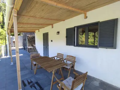a patio with a wooden table and chairs at VViP Vila Madeira in São Vicente