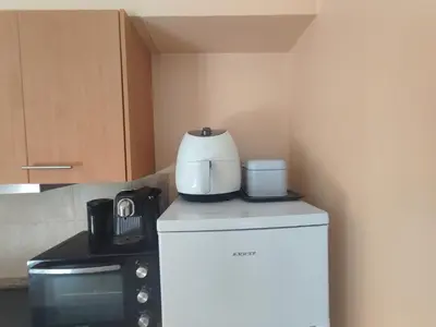 a kitchen with white appliances and wooden cabinets at VViP Vila Madeira in São Vicente