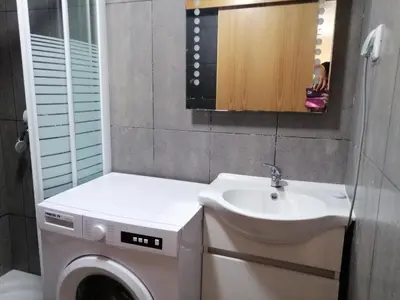 a bathroom with a washing machine and a sink at VViP Vila Madeira in São Vicente