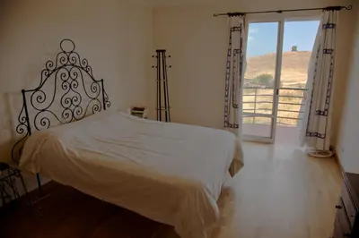 a bedroom with a bed and a large window at Casa Da Atalaia in Caniço