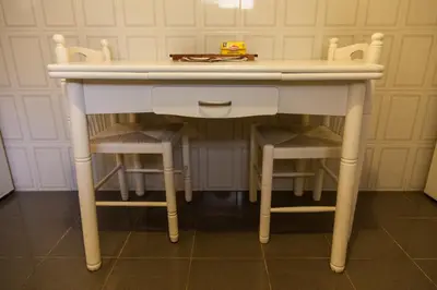 a white table with two chairs under it at Casa Da Atalaia in Caniço