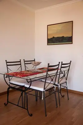 a dining room table with four chairs and a painting at Casa Da Atalaia in Caniço