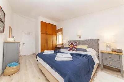a bedroom with a large bed with a blue blanket at C18 - Church Square Apartment in Praia da Luz in Luz