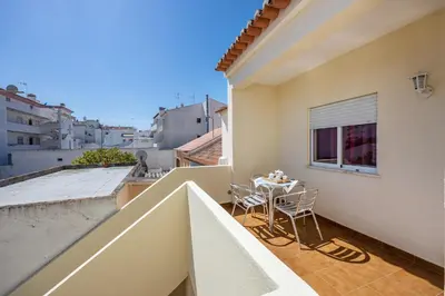 a balcony with a table and chairs on a building at Villas Brites nº4 in Burgau
