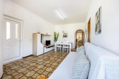 a dining room with a table with chairs and a tv at Villas Brites nº4 in Burgau