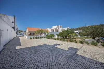 a shadow of a building on a cobblestone street at Villas Brites nº4 in Burgau