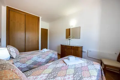 a vase filled with pink flowers in a bedroom at Casa Bege T1 in Burgau