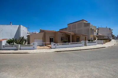 a swimming pool in a villa with two chairs at Casa Bege T1 in Burgau