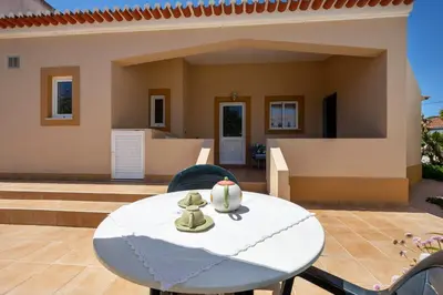 a living room with a green couch and a table at Casa Bege T1 in Burgau