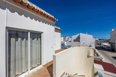 a patio with two blue lounge chairs on a house at Villas Brites nº5 in Burgau