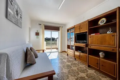 a living room with a bed and a tv at Villas Brites nº5 in Burgau