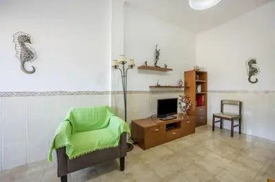 a living room with a chair and a television at Villas Brites nº2 in Burgau