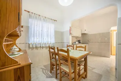 a kitchen and dining room with a table and chairs at Villas Brites nº2 in Burgau
